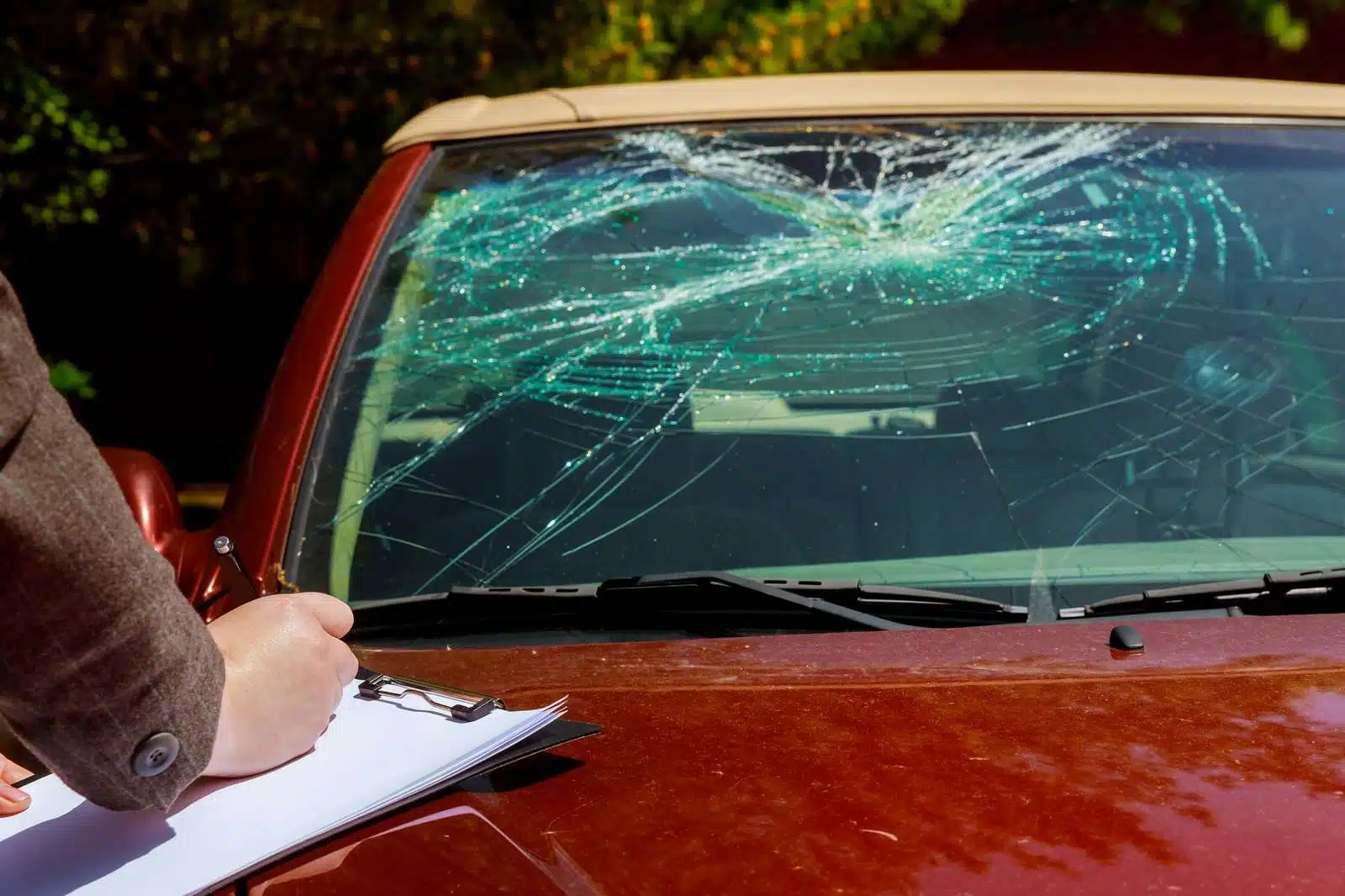 Insurance adjuster documenting a cracked car windshield